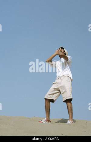Basso angolo di visione di un uomo che grida nel deserto Foto Stock