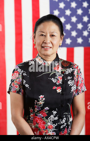 Senior donna asiatica in piedi nella parte anteriore della bandiera americana Foto Stock