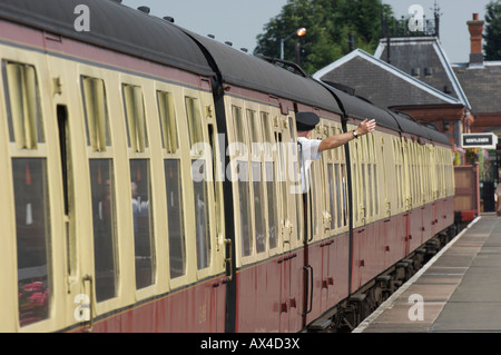 Treno a vapore con carrozze e la guardia a Kidderminster stazione sul Severn Valley Railway Inghilterra Foto Stock