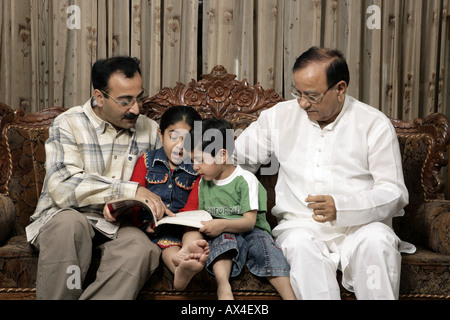 Padre insegnando ai bambini in un soggiorno Foto Stock