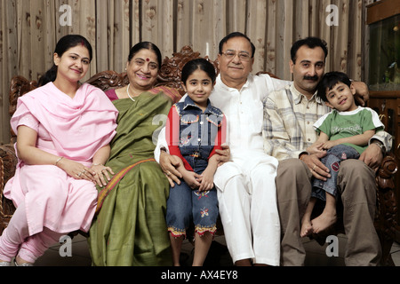 Ritratto di una famiglia comune seduto in una stanza vivente Foto Stock