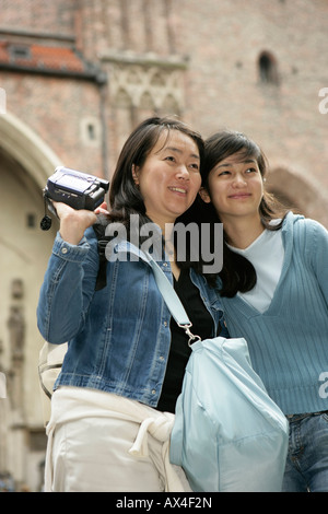 Due donne asiatiche in piedi di fronte ad un edificio medievale, il fuoco selettivo Foto Stock