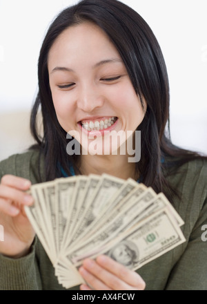Donna asiatica conteggiare denaro Foto Stock