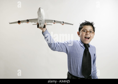 Ritratto di un ragazzo giocando con un aeroplano giocattolo Foto Stock