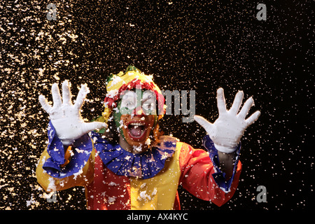 Ritratto di un joker esibirsi sul palco con i confetti a cadere su di lui Foto Stock
