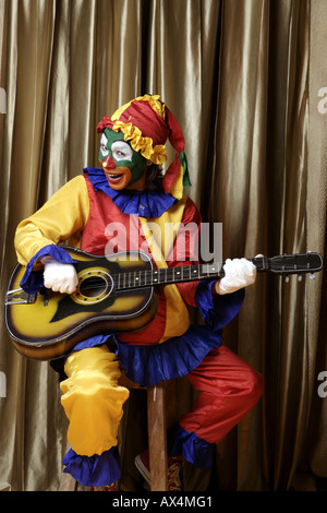 Joker a suonare la chitarra e sorridente Foto Stock