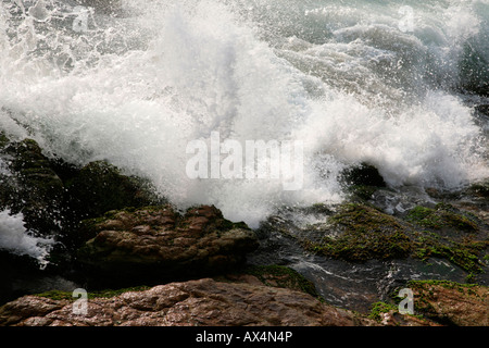 Forme d'onda colpendo la roccia Foto Stock