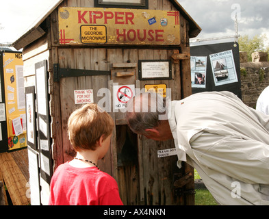 Uomo e ragazzo cerca nella finestra di legno kipper casa di fumo Foto Stock