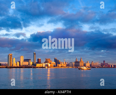 Nel tardo pomeriggio di sole il Liverpool traghetto passa di fronte al contemporaneo e storico waterfront. Foto Stock