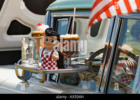 Classic 1950 auto con Drive In Vassoio ristorante attaccato alla finestra e Miniatura Big Boy statua holding Hamburger bicchiere di coca Foto Stock