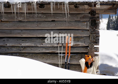 Donna seduta davanti al rifugio alpino Foto Stock