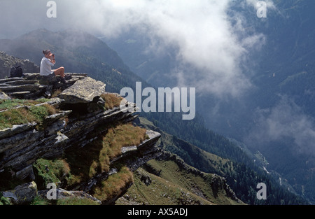 Donna che guarda attraverso il binocolo al Radlgraben, Hohe Tauern, Carinzia, Austria Foto Stock