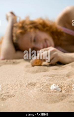 Giovane donna sulla spiaggia, guscio di contenimento Foto Stock