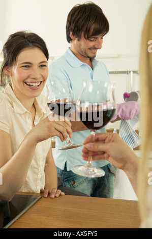 Donna di tostatura, di uomo che lavora in background, sorridente Foto Stock