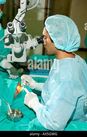 Medico guardando attraverso un microscopio durante la chirurgia della cataratta in PIETERMARITZBURG, Sud Africa e Africa Foto Stock