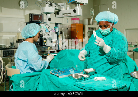 Medico guardando attraverso un microscopio durante la chirurgia della cataratta in PIETERMARITZBURG, Sud Africa e Africa Foto Stock