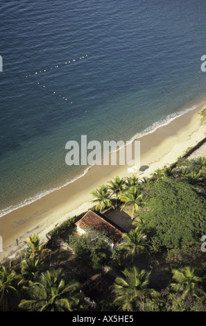 Ilha Grande, Brasile. Veduta aerea della casa sulla spiaggia circondata da palme e con la linea del marcatore di galleggianti. Foto Stock