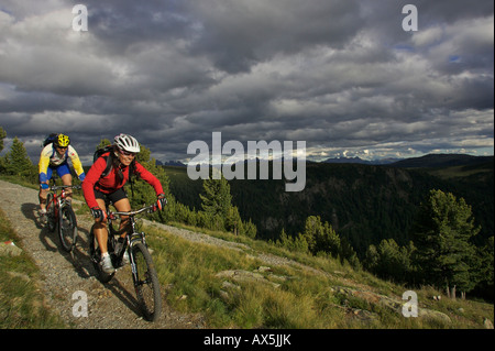 Maschio e femmina mountain bikers a Gedrum pascolo alpino nelle Dolomiti, Sarentino, Bolzano, Italia, Europa Foto Stock