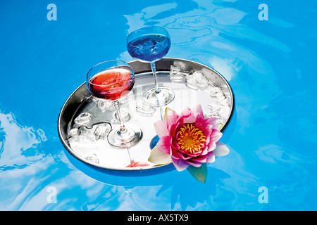 Le bevande sul vassoio galleggianti in piscina, vista in elevazione Foto Stock