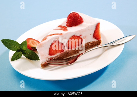 Pezzo di fragole e panna torta di formaggio sulla piastra Foto Stock