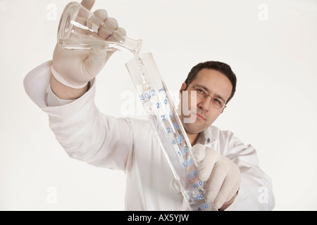 Farmacia versando il liquido in un pallone Foto Stock