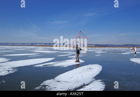 Pattinatore su ghiaccio con vela presso la Neusiedler See in inverno Foto Stock