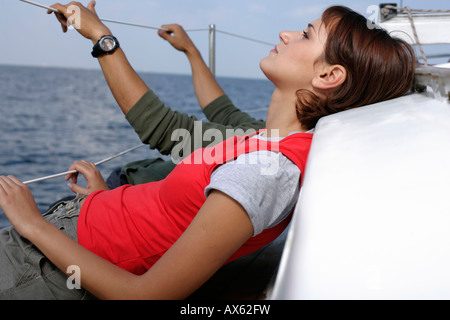 Giovane che giace a bordo di barche a vela Foto Stock