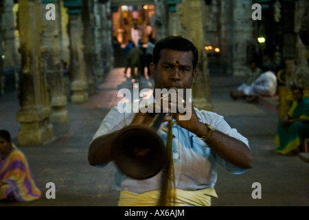 L'uomo gioca un cornuto strumento durante una processione al Tempio di Madurai a Madurai India Foto Stock