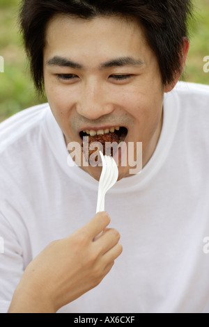 Un padre di mangiare pollo fritto Foto Stock