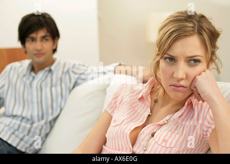 Insoddisfatto giovane donna, uomo seduto in background Foto Stock