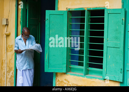 Il vecchio uomo indiano leggendo un giornale in città giudeo Mattancherry India Foto Stock