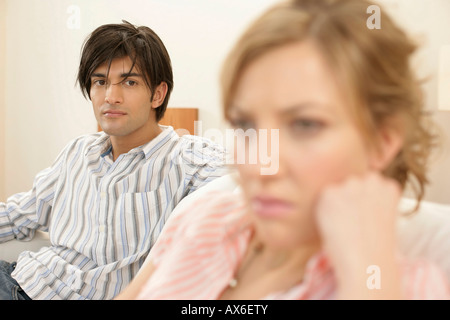Insoddisfatto giovane donna, uomo seduto in background Foto Stock