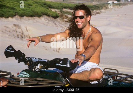 Giovane uomo su moto quad. Sorridendo felice ricreazione Foto Stock