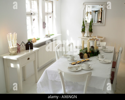 Torte con candele accese e pigne sul tavolo da pranzo Foto Stock