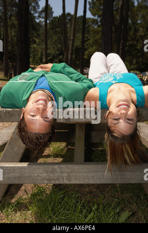 Coppia giovane sdraiato su un tavolo da picnic Foto Stock