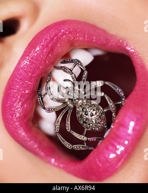 Donna con il ragno gioiello nella sua bocca Foto Stock