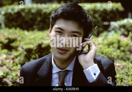 Un giovane giapponese business man parlando sul cellulare Tokyo Giappone Foto Stock