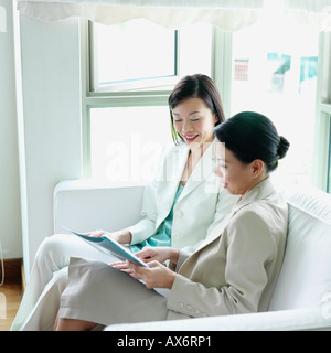 Due imprenditrici seduto su un divano Foto Stock