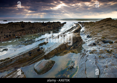 Rockpools e cenge sotto un cielo nuvoloso, Sandymouth, Cornwall Foto Stock