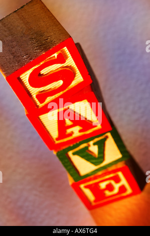 Pila di giocattolo di legno blocchi di costruzione l'ortografia della parola salva Foto Stock