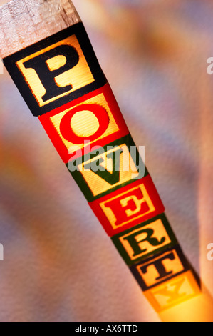 Pila di giocattolo di legno blocchi di costruzione l'ortografia della parola povertà Foto Stock