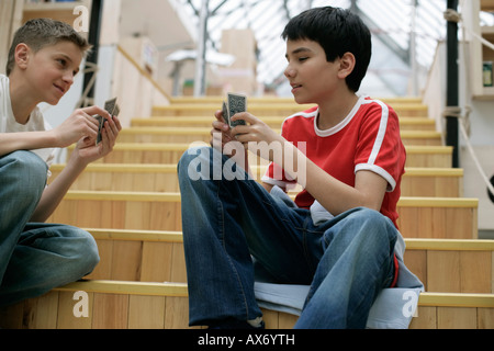 Due ragazzi giocare a carte su una scala, completamente rilasciato Foto Stock