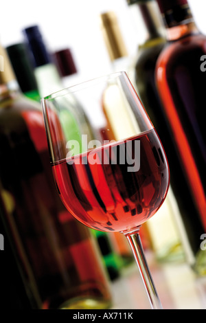 Bicchiere di vino rosato con bottiglie, close-up Foto Stock