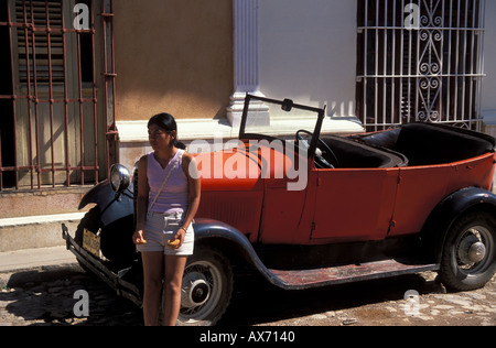 Donna in piedi da red oldtimer Ford Modello T tipo in Trinidad, Cuba Foto Stock