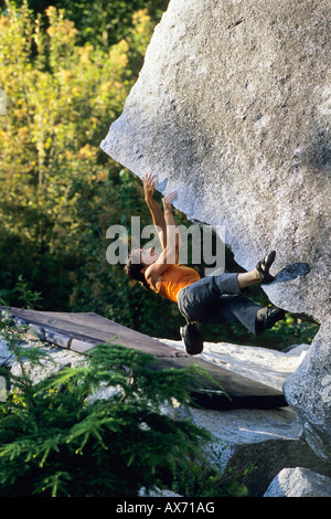 Bouldering femmina sul bordo di taglio V4 grembiule massi Squamish British Columbia Canada Foto Stock