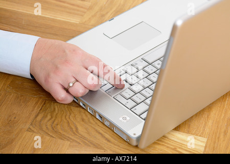 Close up di business womans mano lavorando da casa con il computer portatile su soppalco in legno piano Foto Stock