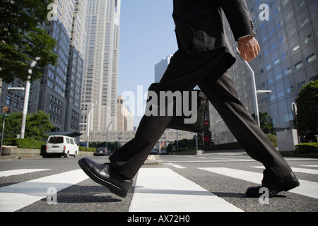 Imprenditore camminando su un crosswalk Foto Stock