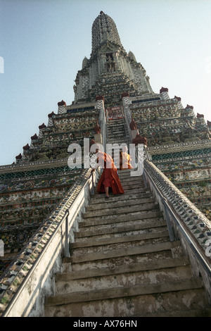 Due monaci tailandesi Climbing Wat Arun (Thai: วัดอรุณ, il tempio dell'alba,) Bangkok in Thailandia Foto Stock