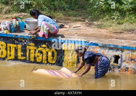 Le donne a lavare i panni e un tappeto di Hesse in un fiume, Tamil Nadu, India Foto Stock