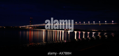 Ponte Humber illuminata di notte con la riflessione in acqua, preso da Hessle Foreshore guardando oltre a sud Ferriby. Foto Stock